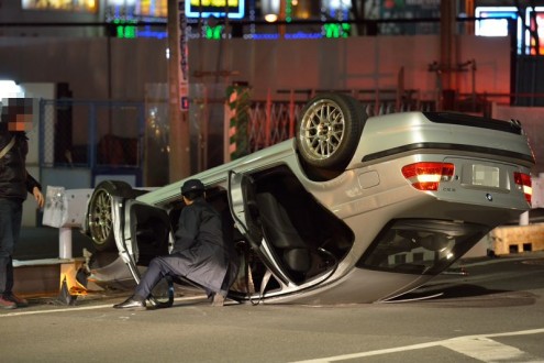 車が横転: 警察官が車内を確認